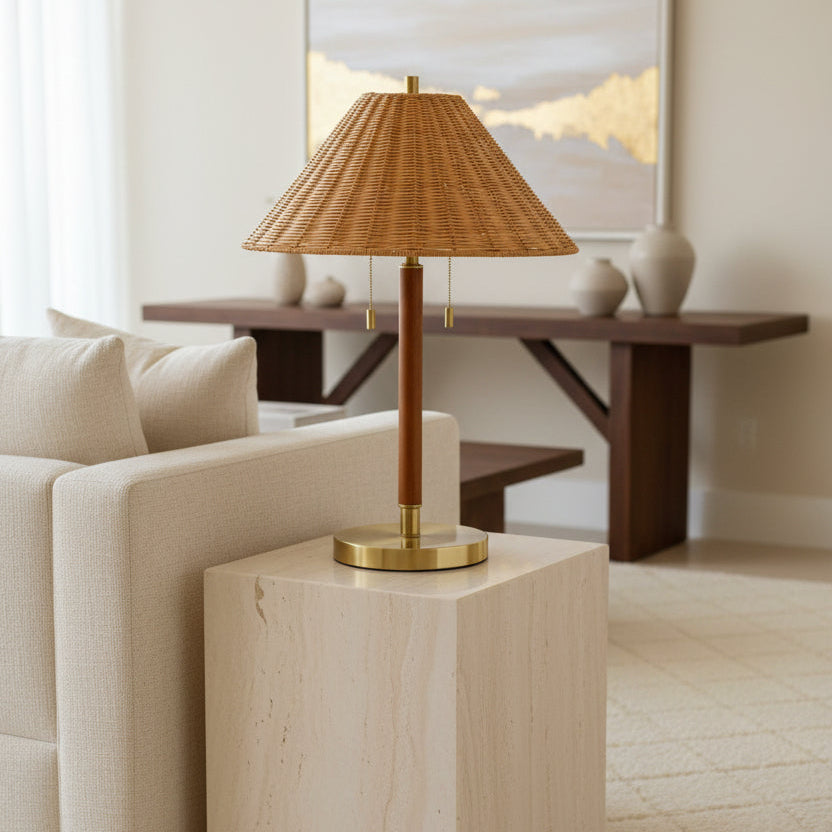 Table lamp with wicker shade and brass base on a white background