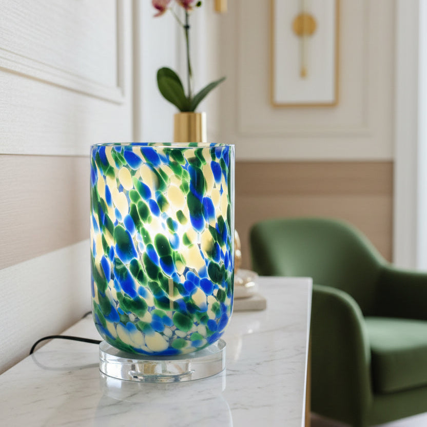 Colorful glass lamp with blue, green, and white pattern on a light gray background