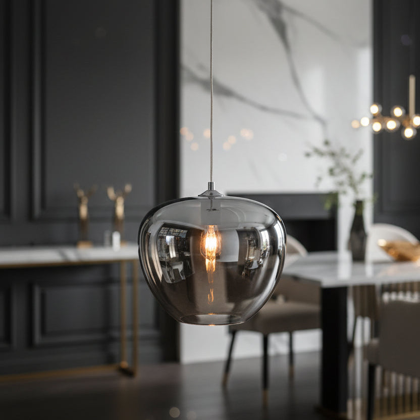 Modern pendant light with a reflective glass shade on a black background
