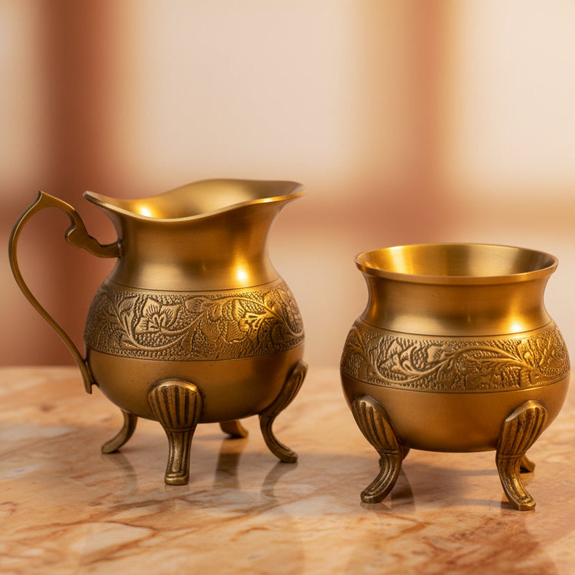 Two ornate brass pitchers on a white background