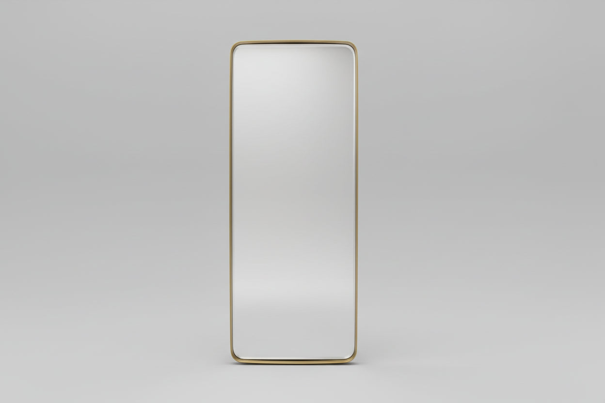 Large floor mirror with gold frame reflecting a bedroom interior.