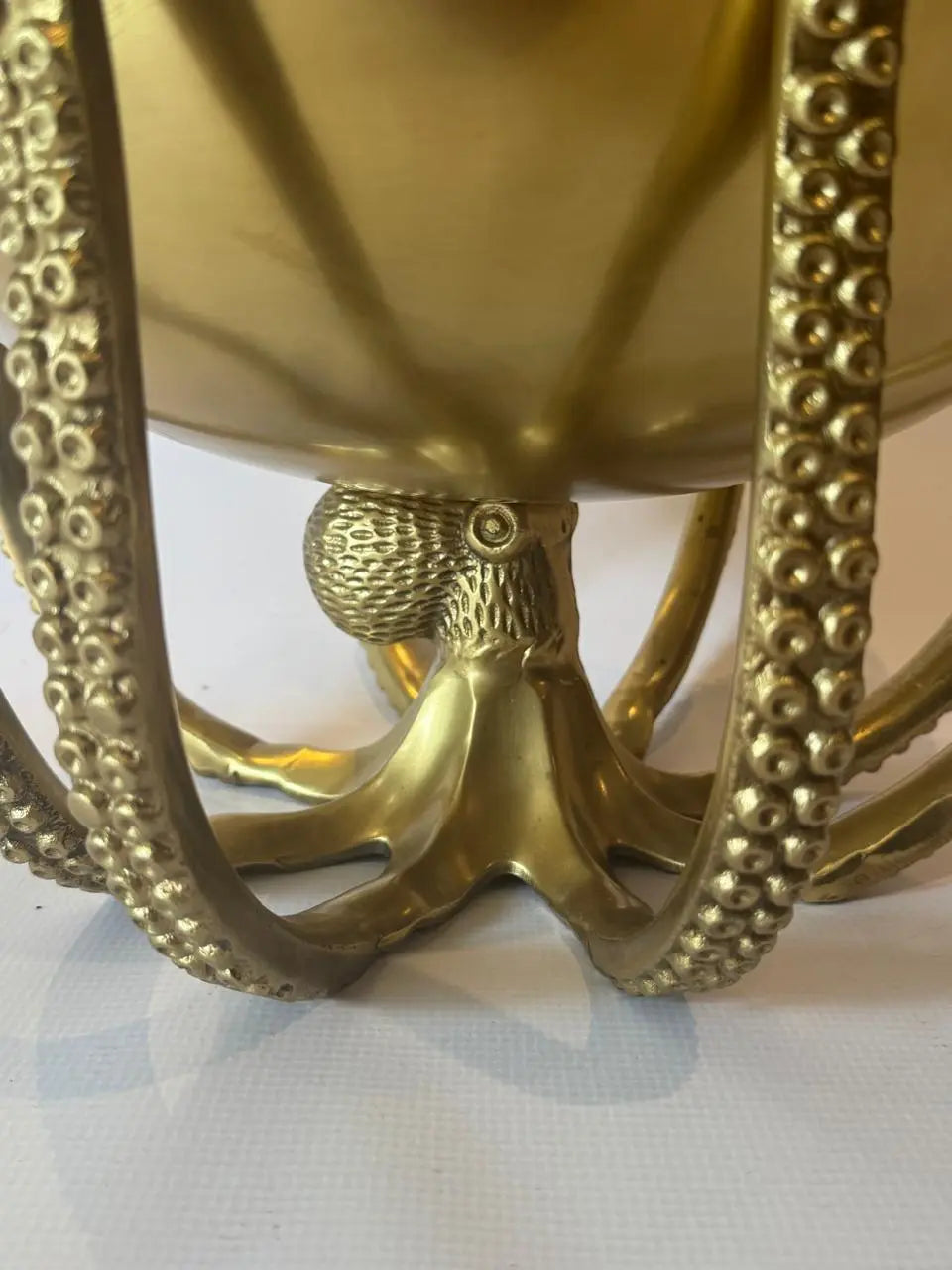 Decorative brass candle holder with intricate design on a white background