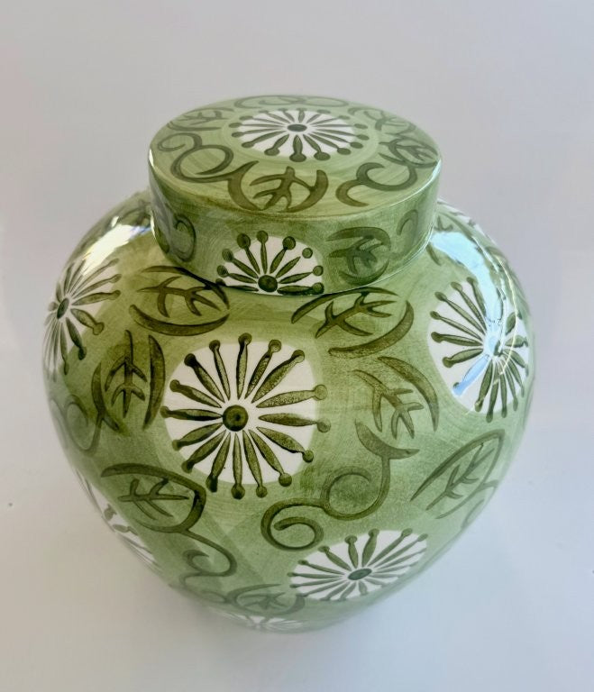 Green ceramic jar with decorative patterns on a white background