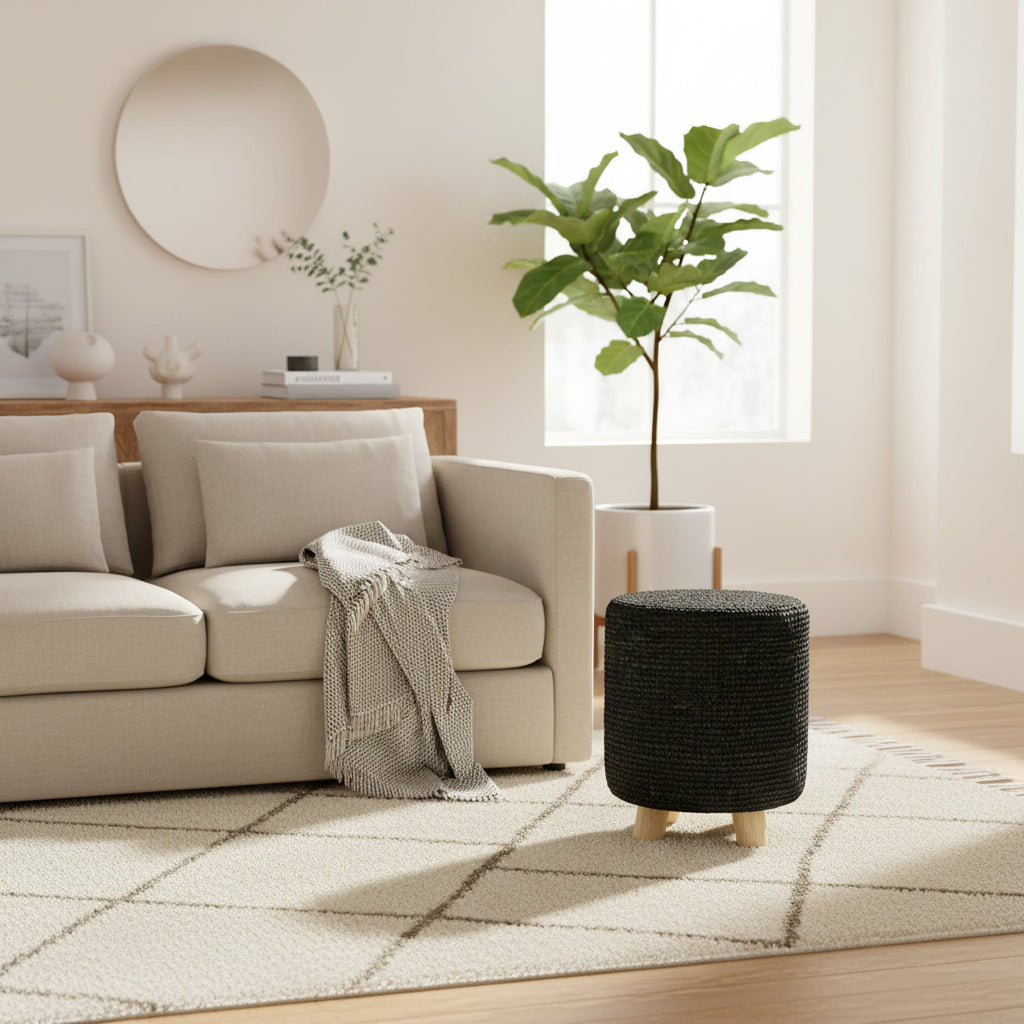 A cylindrical woven basket stool with a dark charcoal black body and light natural wood legs, shown against a plain white background.
