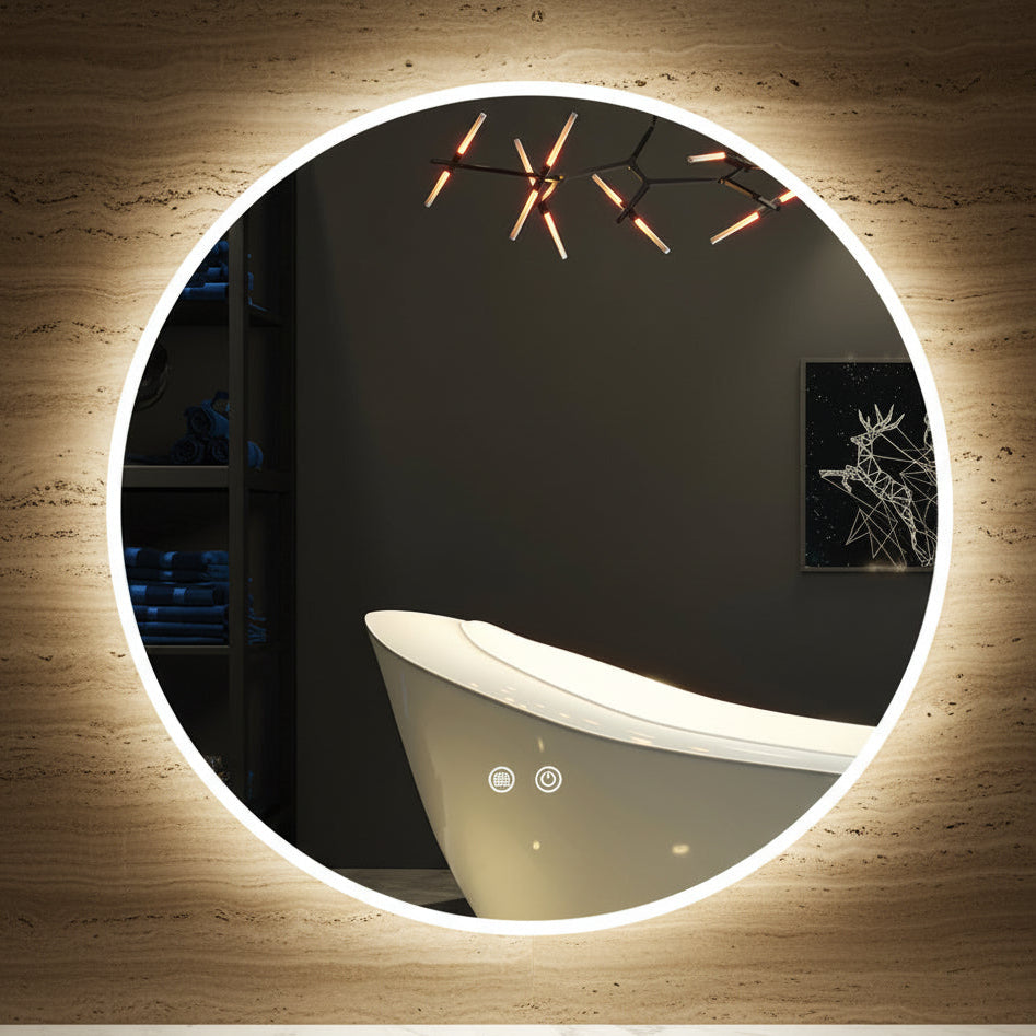 Round illuminated mirror in a dark room with a bathtub and wall art.