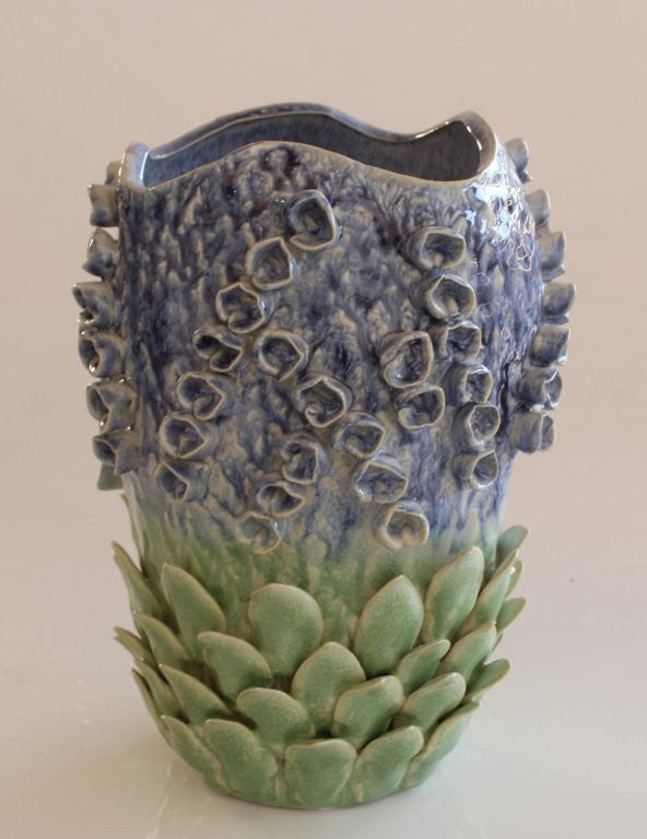 Ceramic vase with textured surface and gradient color on a beige background