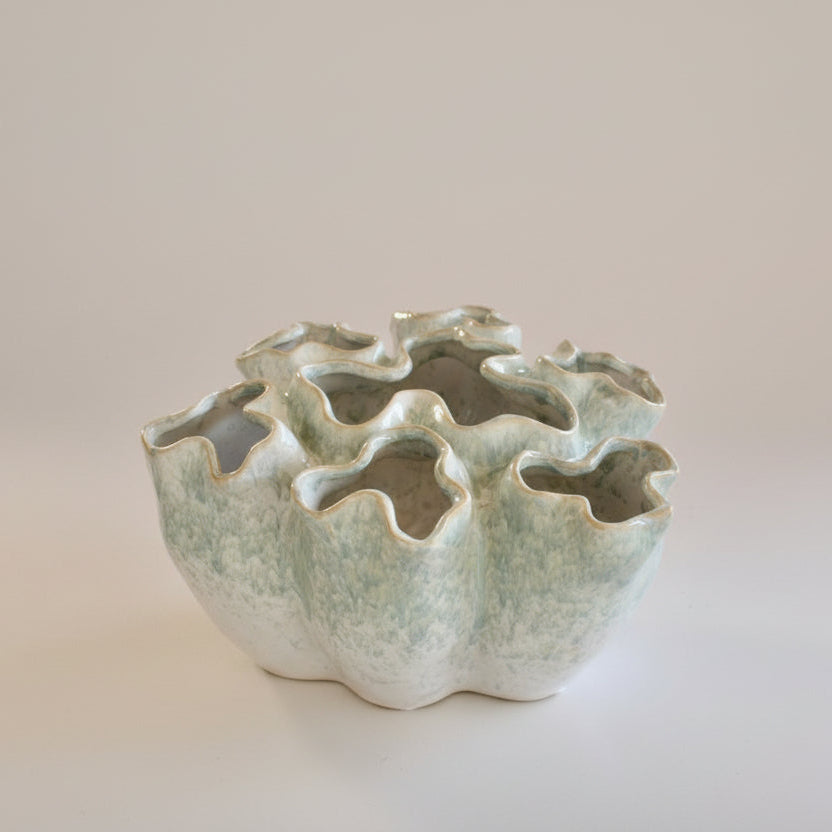 Ceramic vase with unique design on a plain background