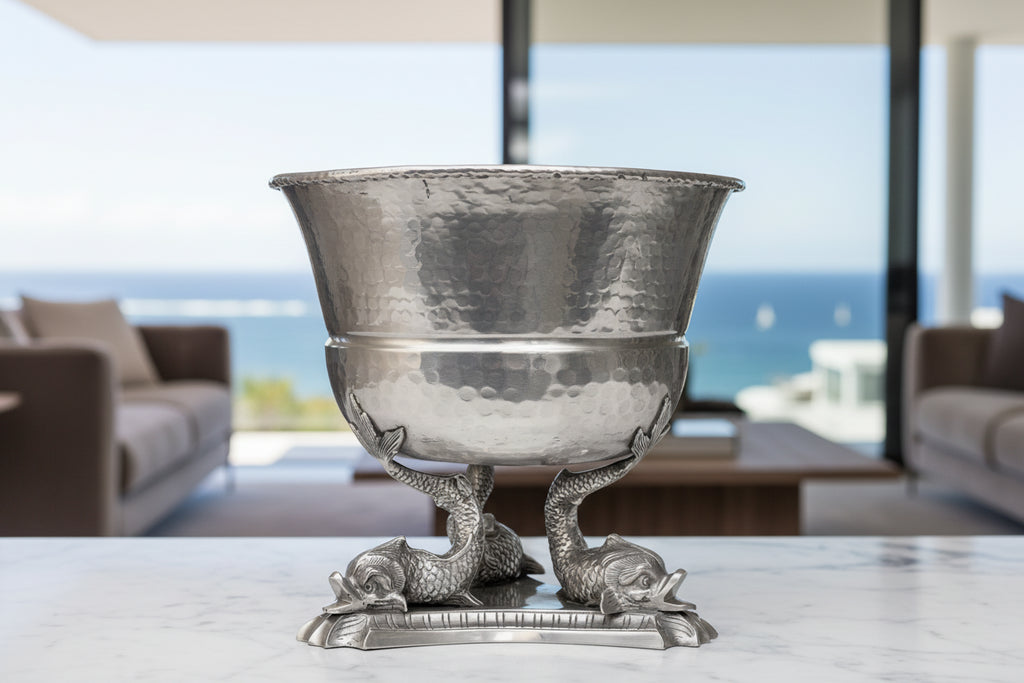 Silver bowl with mermaid designs on a white background