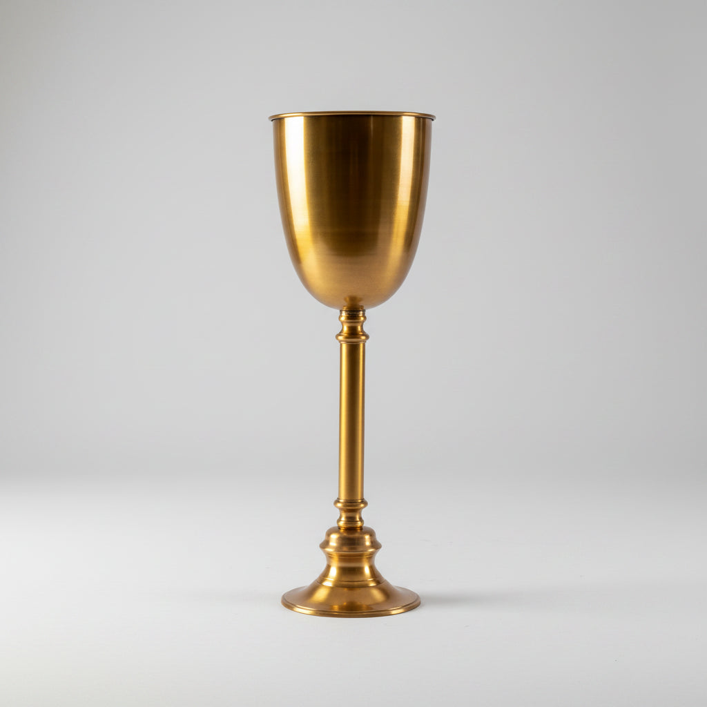 A polished brass or gold-toned metal standing champagne cooler bowl with a wide flared bowl, a slender stem, and a circular base, isolated on a white background.