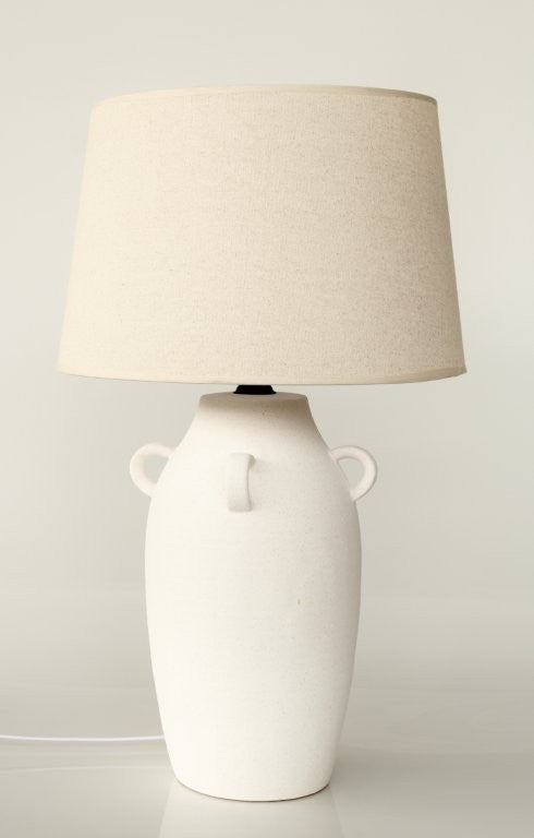 White ceramic lamp with beige lampshade on a light gray background