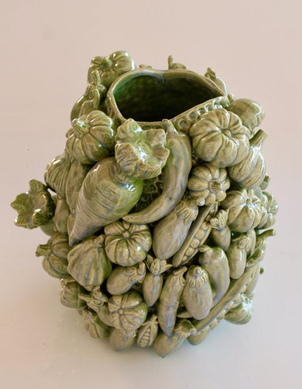 Decorative green ceramic vase shaped like a bundle of vegetables on a light pink background