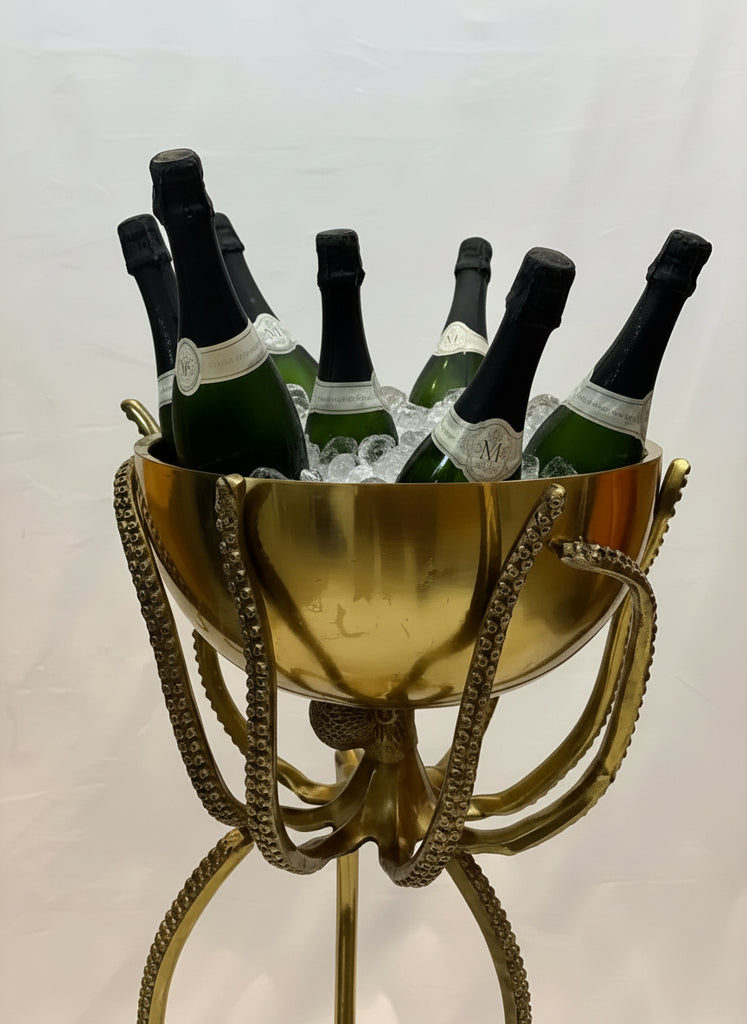 Gold ice bucket with champagne bottles on a light background