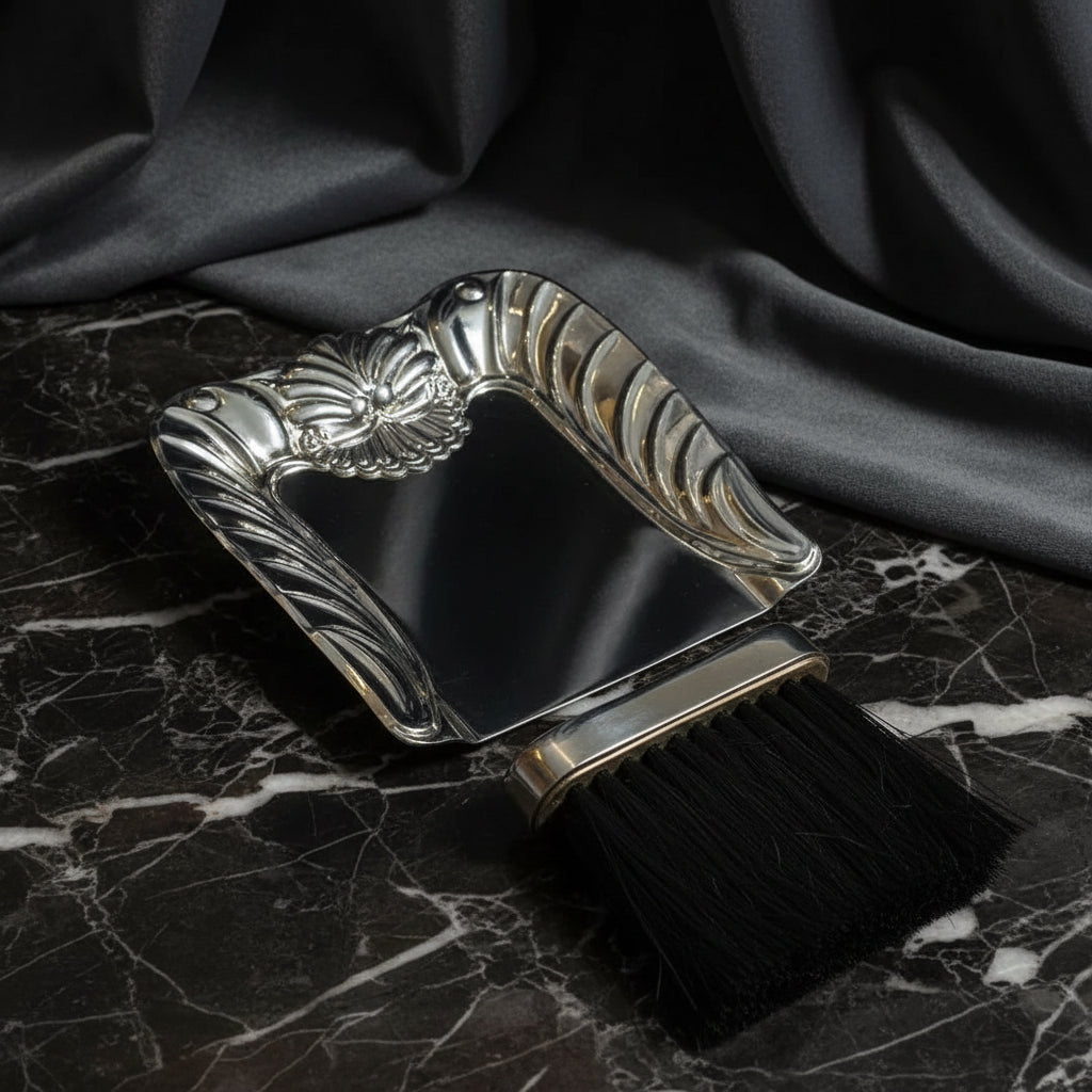Metallic dustpan and brush set on a white background