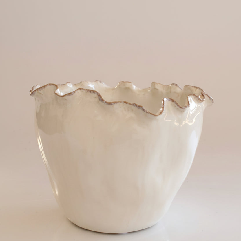 White ceramic bowl with ruffled edge on a light background