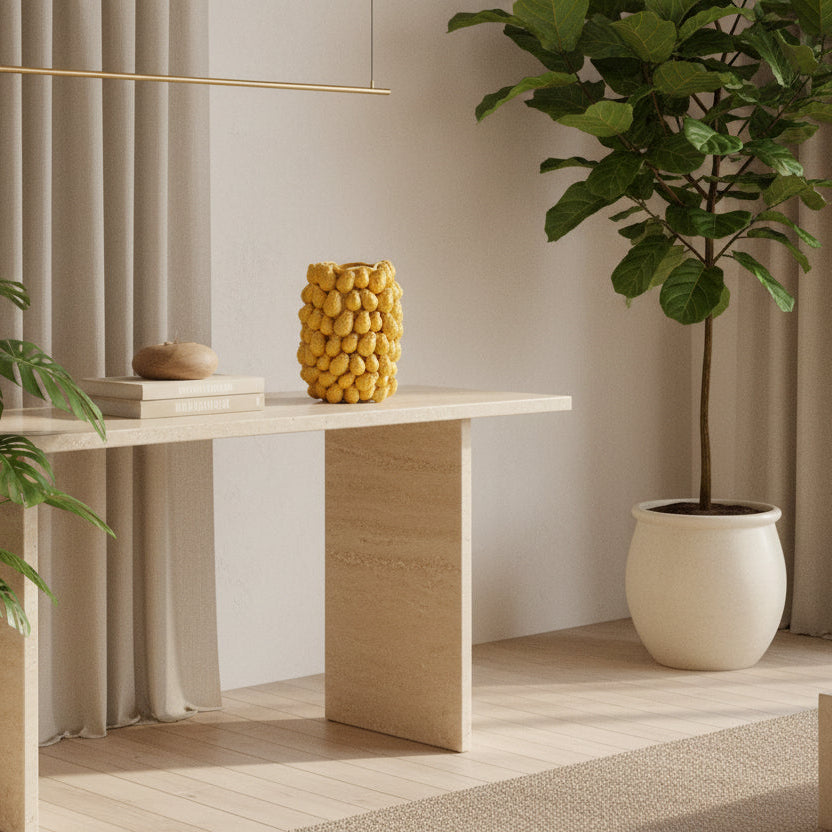 Yellow ceramic vase with textured surface on a beige background