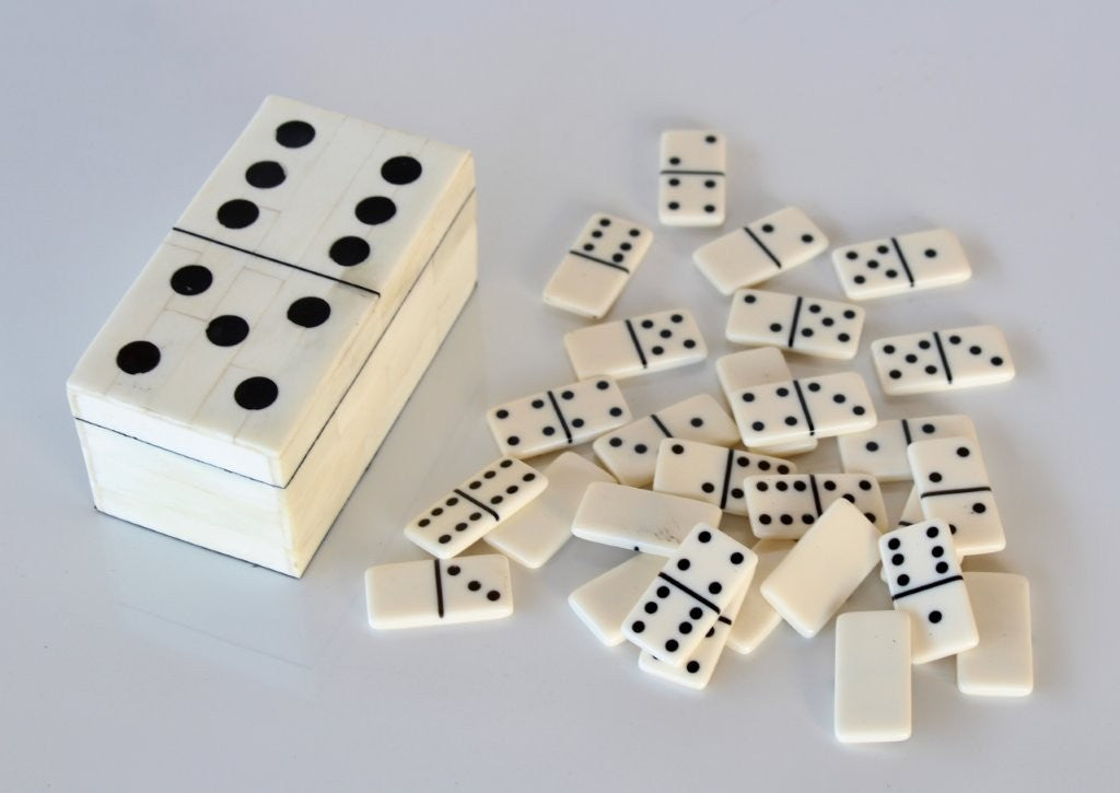 Set of dominoes with a wooden box on a light gray background