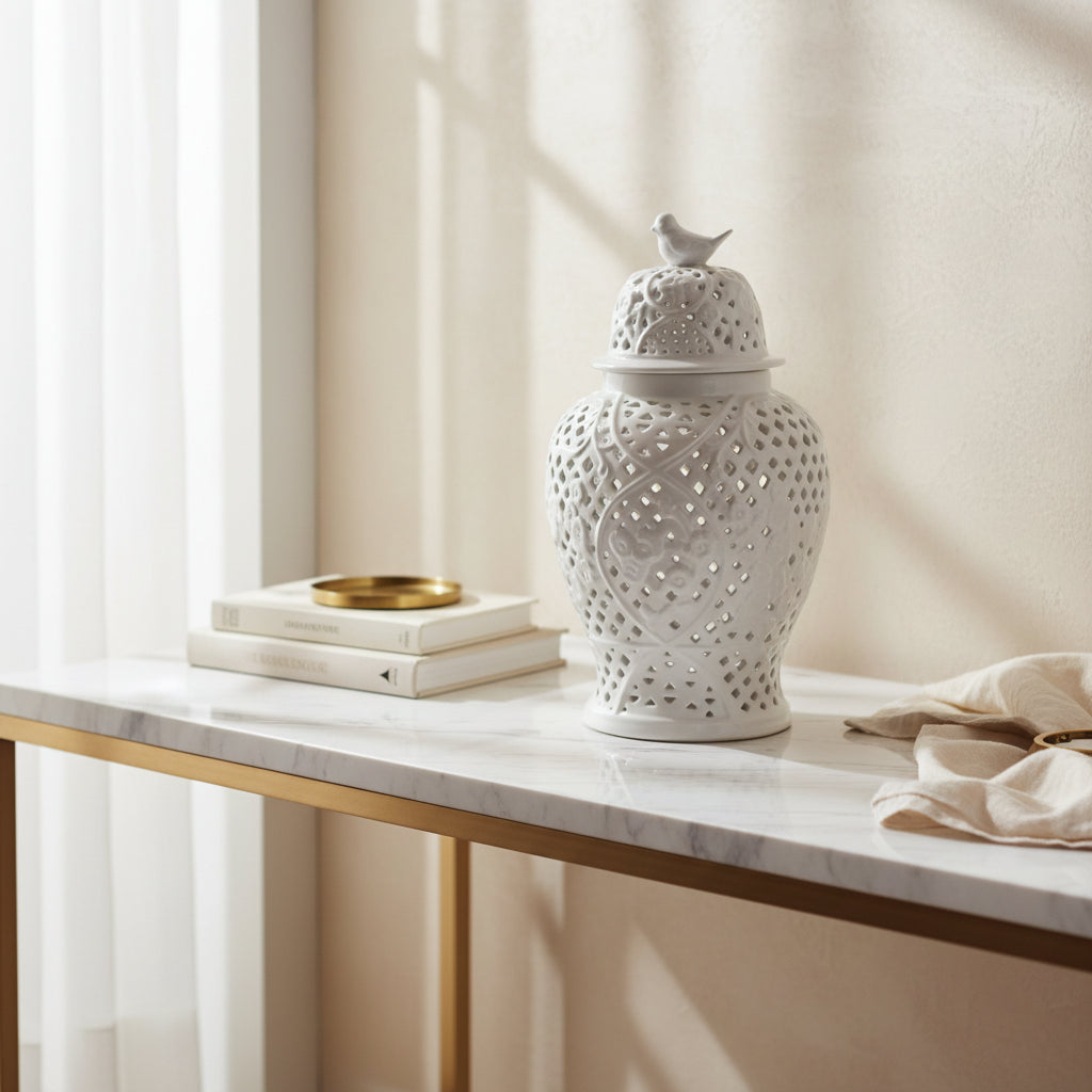 White ceramic vase with intricate lattice design and a small white bird on top against a plain background